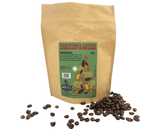 Kraft paper bag of Christmas coffee with coffee beans on a white background