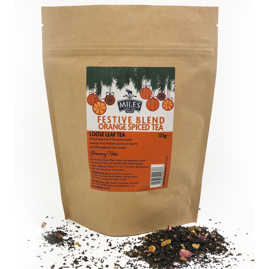 Kraft paper bag of Miles Tea Company festive blend orange spiced tea with loose leaf tea on a white background