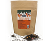Kraft paper bag of Miles Tea Company festive blend orange spiced tea with loose leaf tea on a white background