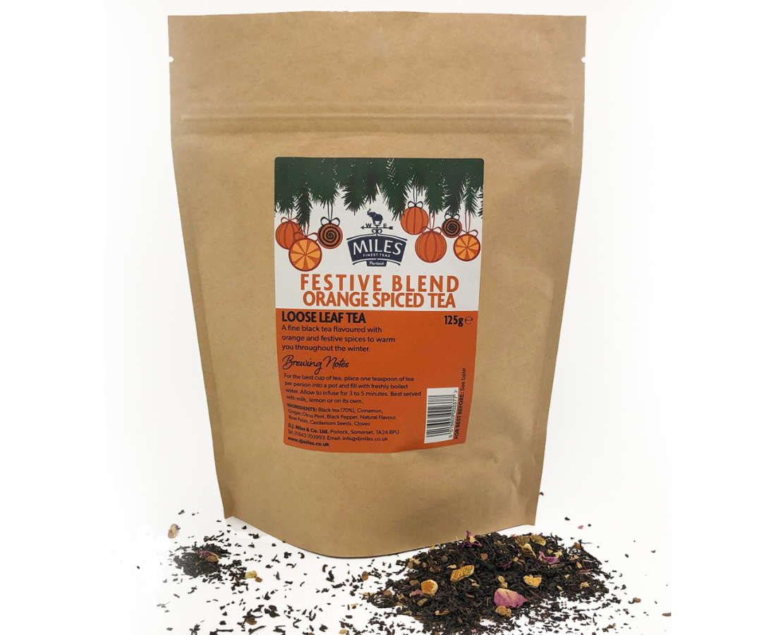 Kraft paper bag of Miles Tea Company festive blend orange spiced tea with loose leaf tea on a white background