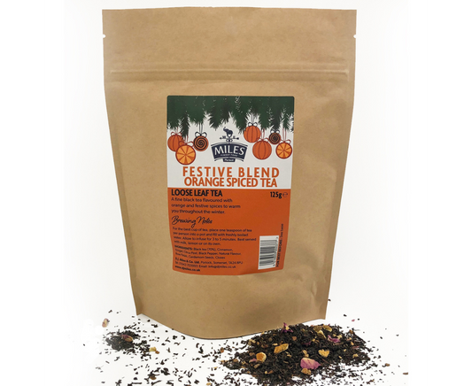 Kraft paper bag of Miles Tea Company festive blend orange spiced tea with loose leaf tea on a white background