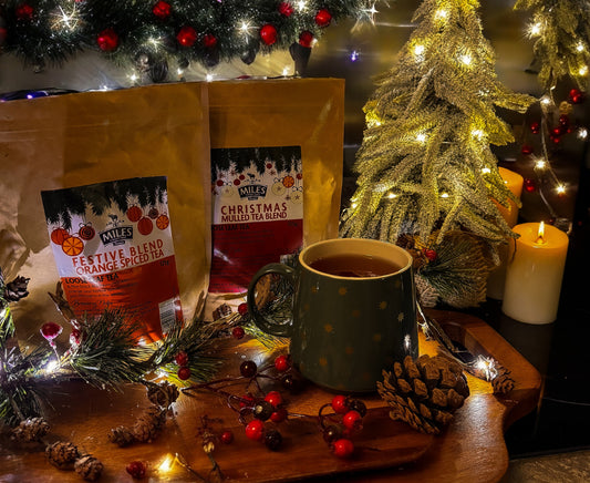Miles Christmas tea with a mug on a wooden tray in front of a decorated Christmas tree.