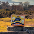 Miles Smugglers Gold tea box on a wooden post with a scenic background