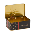 An open rectangular metal tin with a shiny gold interior and lid, featuring a black exterior decorated with gold Christmas tree and snowflake motifs, a red vertical stripe, and the words 'Seasons Greetings' in gold script.