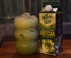 Matcha Vista matcha concentrate box next to a green drink with ice cubes on a wooden surface.