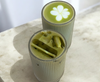Two cylindrical glasses filled with matcha on a light surface.