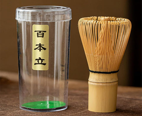 Clear container with a bamboo whisk on a brown surface